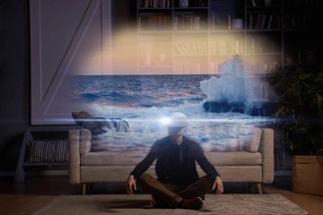 A person meditating in a living room with a surreal ocean scene projected above their head.